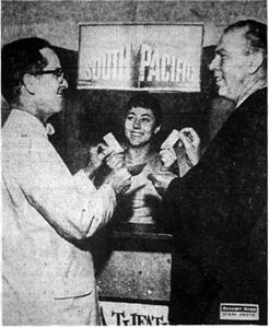 "LOOK WHO'S BUYING TICKETS! - Although they are donating the theater for 'South Pacific' premiere, John Denmen, left, city manager of Fox Wasatch Theaters, and Dick Frisbey, manager of the Villa Theater, purchase tickets for 'South Pacific' benefit premiere. Inez Hales is the cashier." - , Utah