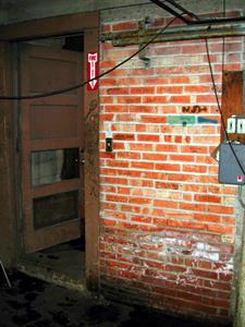 On the left, the exterior door is open to the stairs.  On the brick on the right of the doorway are signatures of many of the theater employees. - , Utah