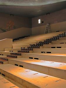 A dozen seating risers at the back of the auditorium.  The seats have been removed.  A ladder stands on the last row, below an empty speaker bracket. - , Utah