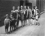 Seven women and two children in bathing suits pose for a photo outside the Pantages Theater.