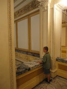 A boy stands at marble railing at the southwest corner of the mezzanine, looking at the lobby below. - , Utah