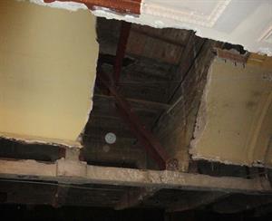A closer view of the damaged ceiling, showing the area between two concrete supports for the balcony.  In the top middle you can see temporary flooring added in the balcony after removal of the escalator. - , Utah