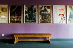 Movie posters line the wall above a bench.