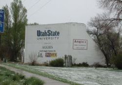 The concrete screen tower of the Drive-In has been painted white and serves as a sign for Utah State University.  The drive-in sits alongside the highway to Logan.