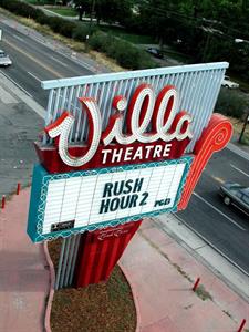 The theater's sign, with most of its surrounding flowerbed, fills a vertical photo. Highland Drive and a parallel street are visible behind the sign. - , Utah