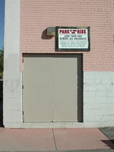 At the north end of the west exterior wall, above exit doors, is a sign reading, 'Park at Your Own Risk. Lock Your Car and Remove All Valuables. Parking lot owner and operator assumes no liability for loss of, or damage to, or theft from any vehicle parked in this facility.' - , Utah