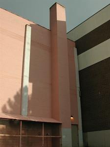 A view of the rear exterior wall of the theater, with the neighboring office building on the right. Exit double doors are on the right, with a chimney on the left, then covered stairway to the basement. - , Utah