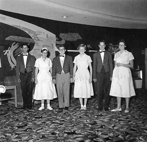 Six employees pose for a photo in the lobby.  The original mural is still visible on the wall. - , Utah