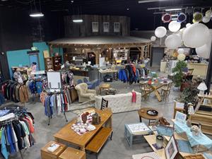 Clothes racks and furniture are arranged randomly across a retail store. A false-front building stands in the back corner. - , Utah