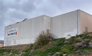 Looking up a hillside at a white brick building. The right third of the building is recessed enough to allow access to a single exterior door at the top of a flight of stairs.  - , Utah