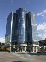 Blue sky and clouds are reflected in the all-glass exterior of the new office building. - , Utah