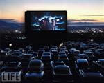 With his arms flung wide, Charlton Heston portrays Moses in a scene from 'The Ten Commandments,' on screen at the Oak Hills Drive In, with the sunset in the background. - , Utah