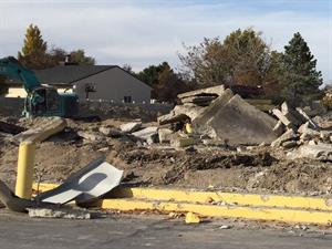 Piles of concrete slabs sit on the ground as excavators continue to dig through the rubble. - , Utah
