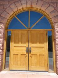 The entrance has wooden double doors with side windows and a half-circle arch above. - , Utah