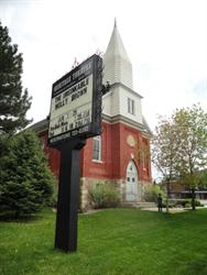 The sign, with the steeple of the former church in the background. - , Utah