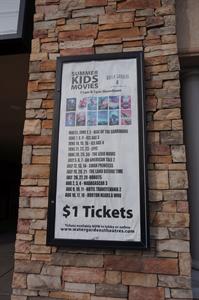 A poster case on a decorative brick pillar with dates for a dozen kids movies. - , Utah