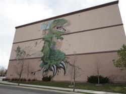 A mural on the northwest exterior wall of a tyrannosaurus rex bursting out of the Mammoth Screen. - , Utah