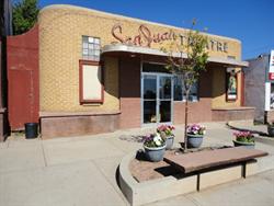 A bench rests on the edge of a half-circle flower bed in front of the theater. - , Utah