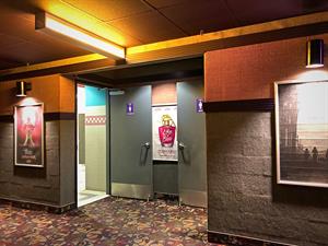 In a recess in the wall, the doors for the restrooms are propped open.  One poster case is between the restroom doors, while the other two are on either side of the recess. - , Utah