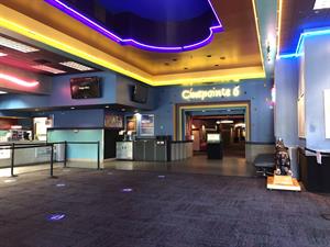 Yellow, purple, and blue neon outline the walls and ceiling of the lobby.  On the left is the Snack Bar.  Above the entry of the auditorium hallway is the name, 'Cinepointe 6', in yellow neon. - , Utah