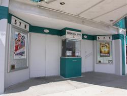 The entrance of the Ritz Theatre has a ticket booth in the center and poster cases on either side. - , Utah