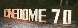 The letters from the Cinedome 70 sign stand in a snowy back yard with Christmas lights strung between them. - , Utah