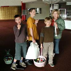Three boys and a woman stand in the lobby with Easter baskets and flashlights. - , Utah