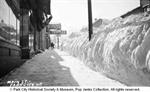 A bank of snow up to eight feet high separates the sidewalk from the street. - , Utah