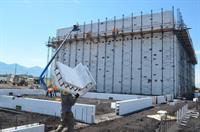 A worker carries a foam block as the auditorium walls are framed. - , Utah