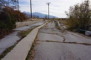 A cracked asphalt lane splits, with one half going down and the other continuing level. - , Utah