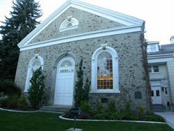 A now-unused entrance door, flanked by windows, in the original portion of the building.