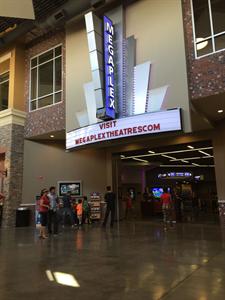 A Megaplex marquee hangs over the entrance to the main theater hallway.  A two-line attraction board directs moviegoers to the Megaplex web site. - , Utah