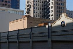 The facade of the printing center, with the upper floor of the Peoples Opera House in the background. - , Utah