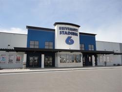 University Stadium 6 has a ticket booth in the center with two sets of entrance and exit doors on either side.