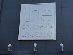Three lights illuminate the sign for "the children's theatre". - , Utah