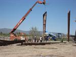 With the help of a crane, workers lift a steel beam into place. - , Utah