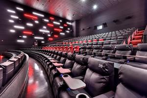 Looking across from the front left corner to the back right. Each row has black recliner seats. Red seats on two rows indicate D-BOX seats.  Red and white lights in varying lengths cover the side walls. - , Utah