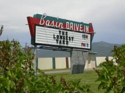 The sign of the Basin Drive-In has a large red arrow pointing towards the theater's entrance.
