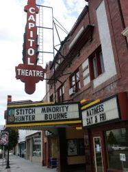 Front of the Capitol Theatre, showing the vertical blade sign and marquee

The Capitol Theatre has a tall, vertical sign attached to the front of the building, with a triangular marquee that extends over the sidewalk. - , Utah