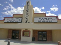 The entrance of the Southtowne Cinema has two sets of doors with an attraction board above each.  Above the ticket booth, in vertical letters, is the name of the theater.