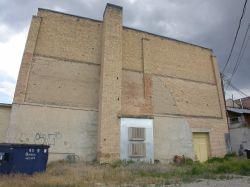 The back exterior wall of the Towne Theatre.  The chimney appears to have been added after the original construction of the theater and partially covers a bricked up doorway or window.  A new exit was added on the right side of the rear wall. - , Utah