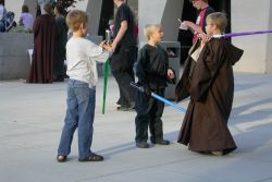 Three young Star Wars fans practice their light saber skills outside the south entrance of the Megaplex 17 at Jordan Commons. - , Utah