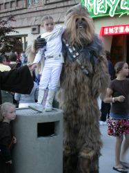 A young girl in a Padme Amidala costume stands on a garbage can while posing with a much taller fan in a Chewbacca costume. - , Utah