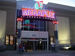Neon on the 'Megaplex at Jordan Commons' marquee at theater's east entrance.  Neon on the back of the sign is reflected in the building's windows.  The east entrance leads directly to the theater's main ticket booth. - , Utah