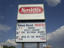 Below the sign for the Smith's grocery store is the sign for the King Koal Theatre.  The opposite site of the sign lists movies and showtimes for the Price Theatre and the Crown Theatre. - , Utah