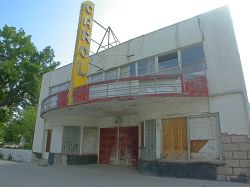 The front of the Carol Theater features a circular marquee with a vertical sign with the name 'Carol'.  Above the marquee is a row of second-floor windows. - , Utah