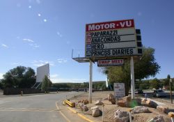 The sign and entry drive of the Motor-Vu Drive-In.  On the left is Screen 4.  In the distance behind the sign are the three main ticket booths. - , Utah