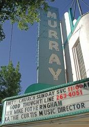 The marquee of the theater has a four-line attraction board and a vertical sign with the name 'Murray'.