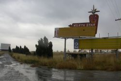 The entrance of the North Star Drive-In, with the theater's sign on the right and the remaining screen in the distance on the left. - , Utah