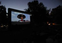 A movie shows on the Open Air Cinema screen at night. - , Utah